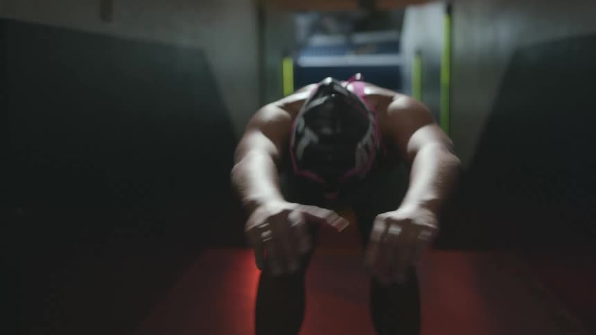 Female swimmer preps in corridor under blinking neon lights