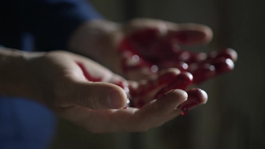Crimson liquid smears hands and drips off fingers