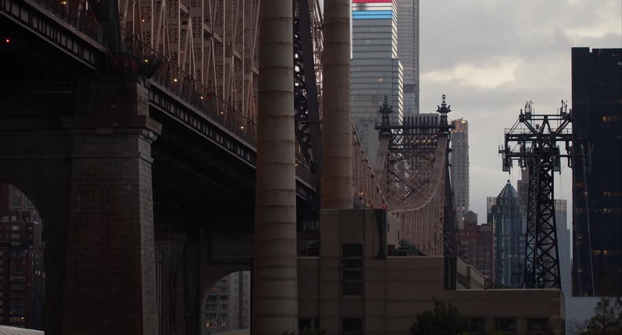 Bridge cuts through city passing skyscrapers and transmission towers