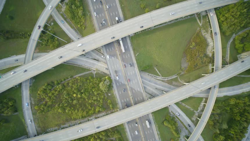 Hyperlapse twist above a large highway interchange as cars and trucks rush through frame