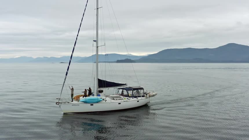 People on a boat in the water are waving their arms as if they are calling for help