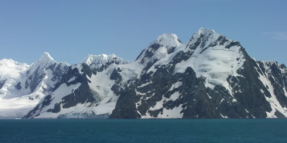 Snow-covered mountain as seen from the water on a clear day