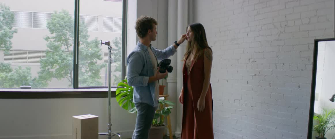 A photographer speaks with a model and takes some photographs