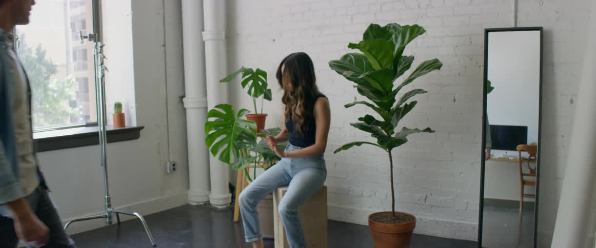 A photographer is planning a photo session with a female model while indoors during the daytime