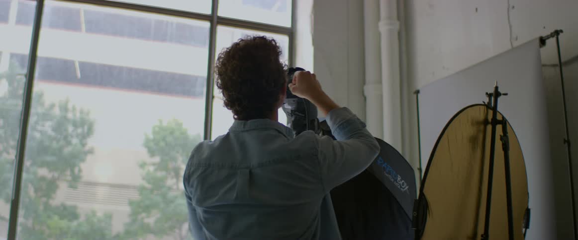 Young photographer adjusting lights inside a studio in the city
