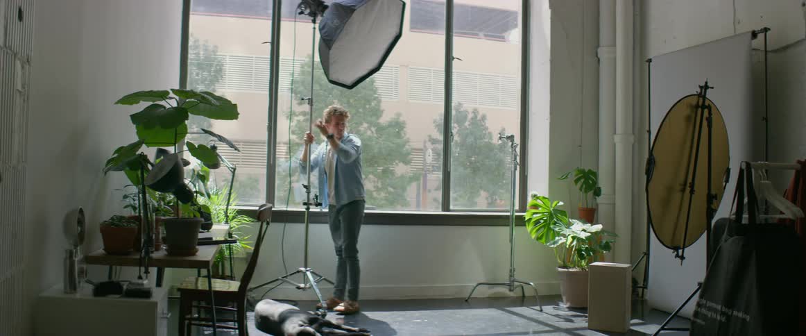 A man is setting up the lights in his studio