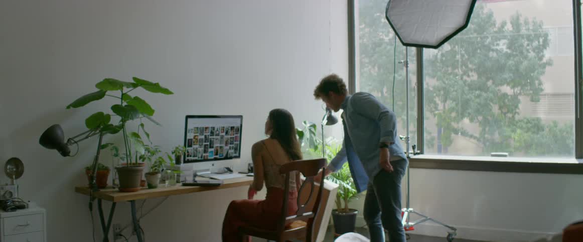 A man and woman sitting down at a computer