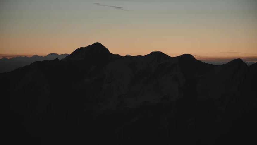 View of mountain ranges being silhouetted against the red sky at dusk
