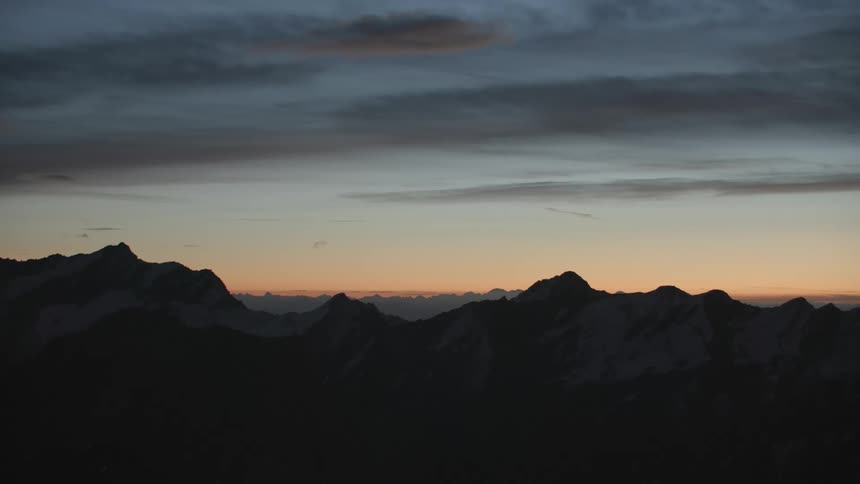 The sun is nearly set behind the mountain range