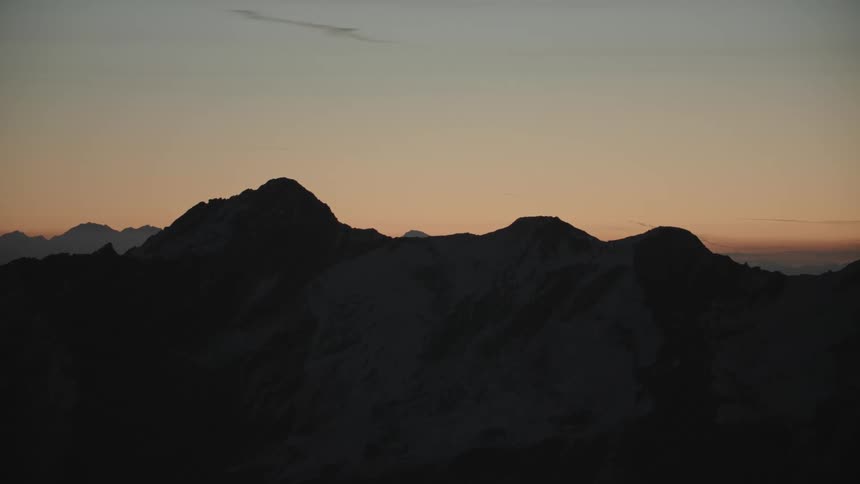 A mountain range under an orange sky