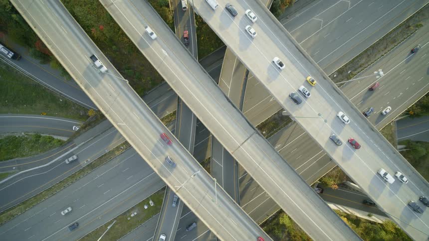 Straight down descent towards highway traffic driving along a maze of ramps and overpass lanes