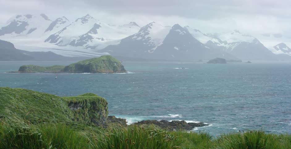 An icy line of mountains near a body of water