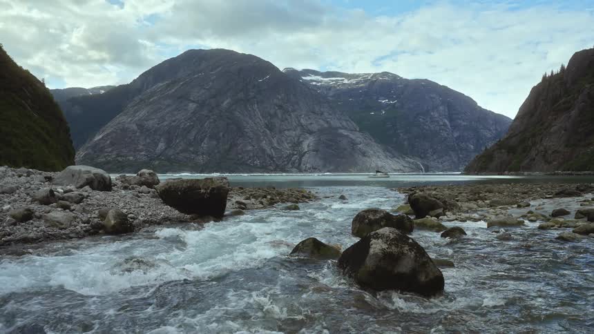 Gentle waves move along boulders on the coast