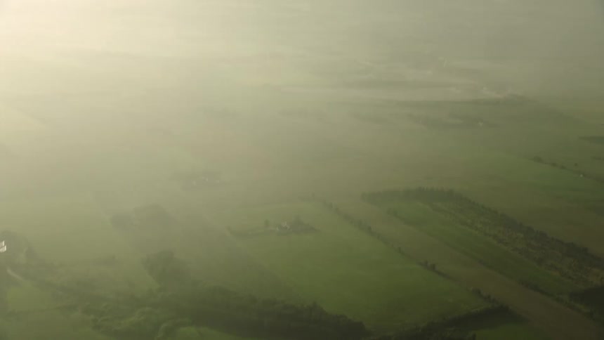 Aerial view of sweeping farmland on the plains under the haze at morning