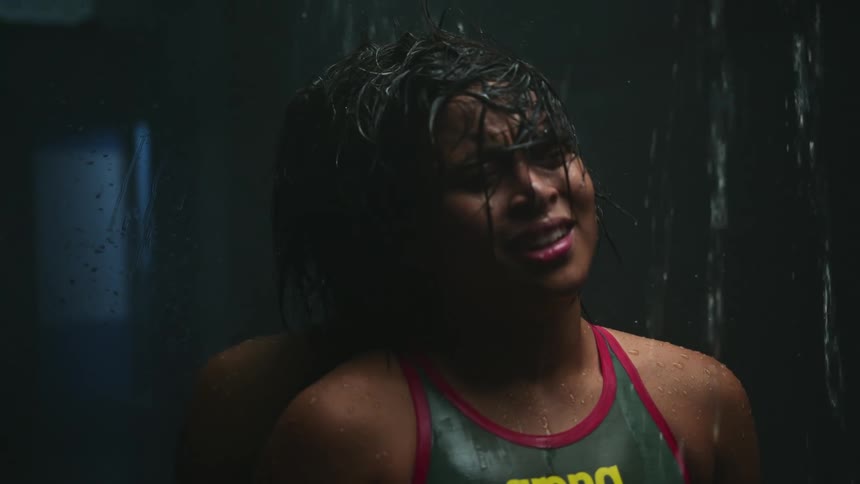 A woman standing in a shower and crying