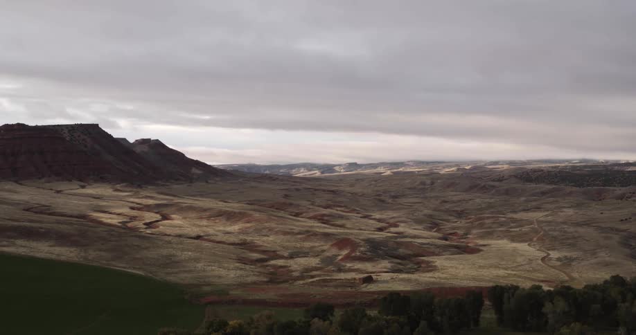 Plainsborders field forest and mountains under overcast sky