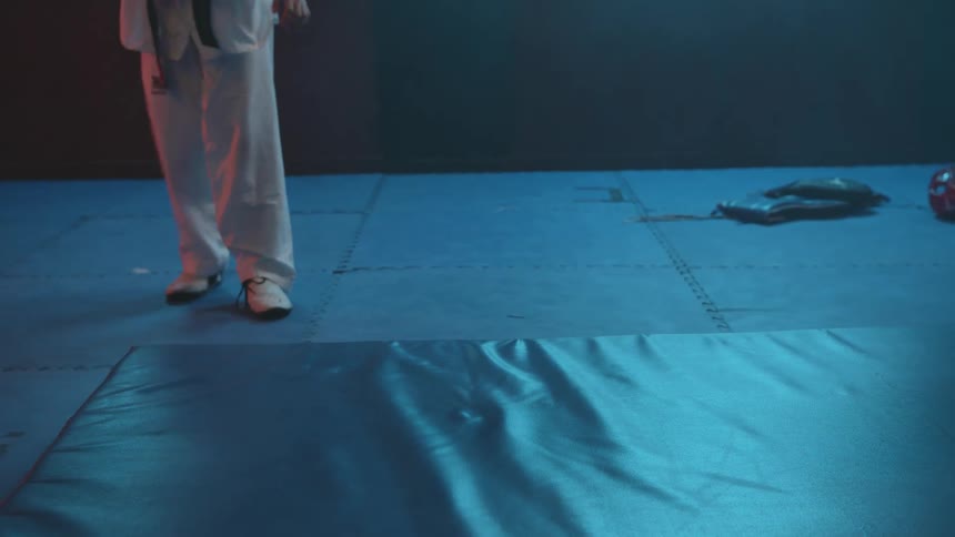 Female martial artist practice kick falling onto thick pad