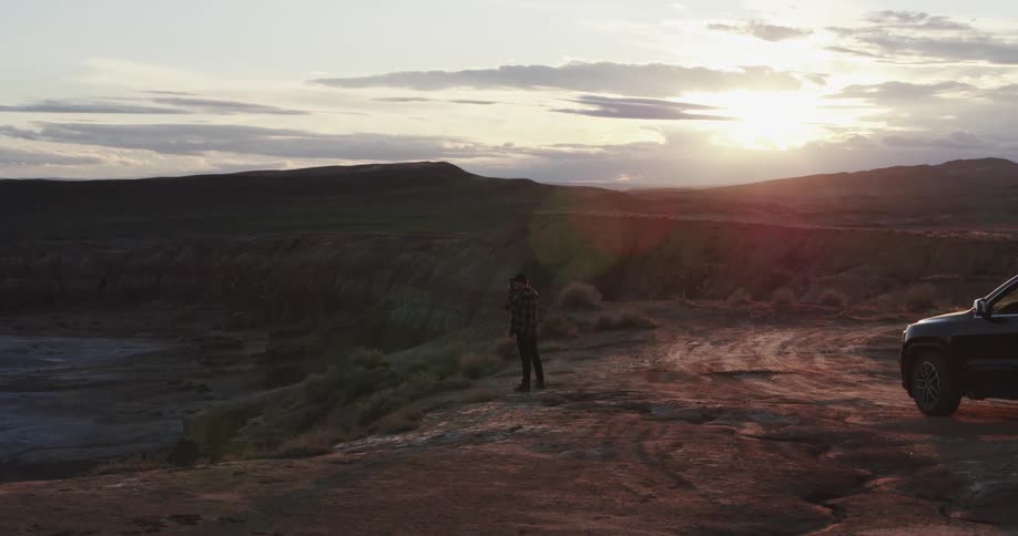 A man hikes from his vehicle to the cliff to take a photograph
