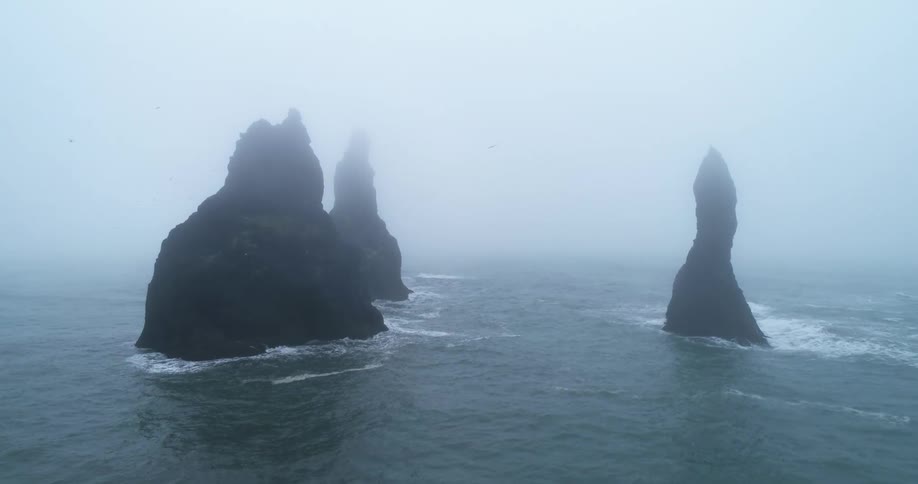 Strong waves crash into sea stacks in the ocean