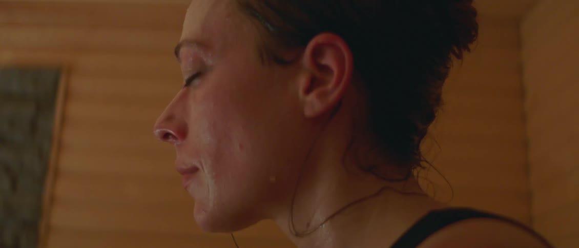 A woman is sweating in a sauna