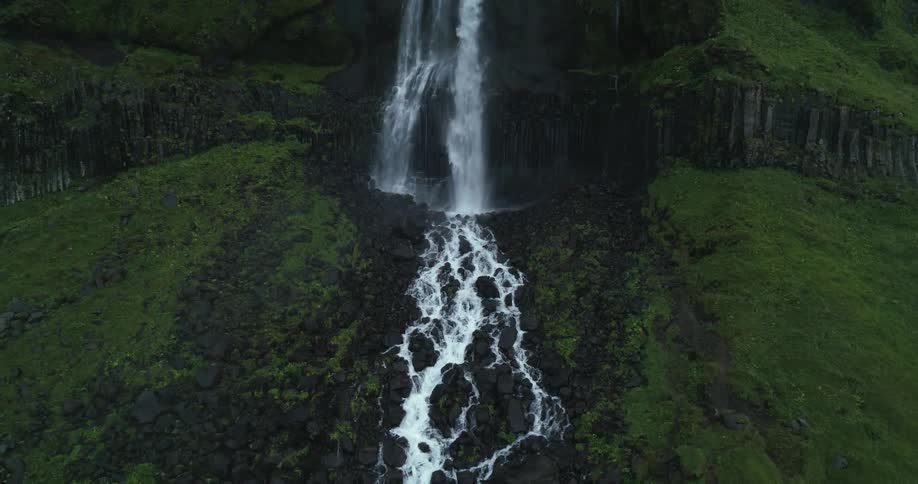 A large waterfall pours water down the mountain