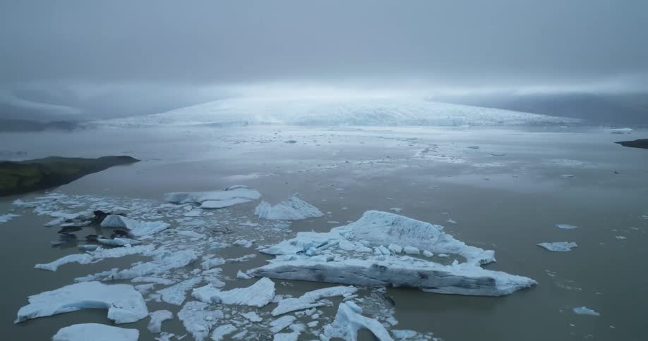 Broken pieces of an iceberg are scattered through the ocean
