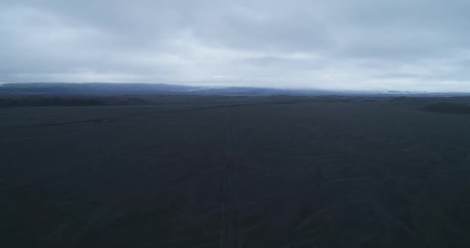 Tire marks run the length of a vast open field