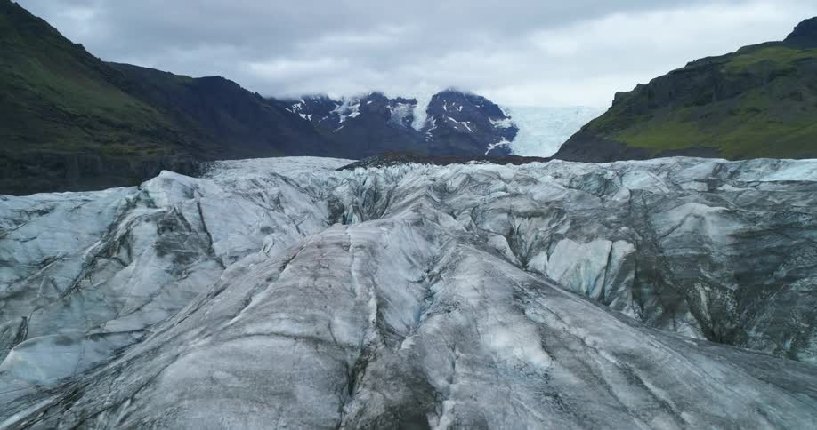 Glaciers of ice with a mountain range the sky and clouds in the background