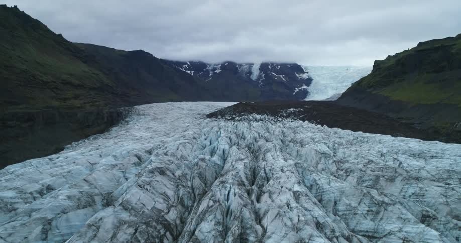 A curving glacier that looks like it is flowing down a mountain ridge