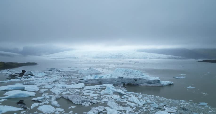 A landscape with glaciers and water with the sky and clouds in the background