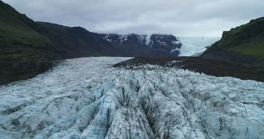An aerial view of a glacier in the middle of a mountain