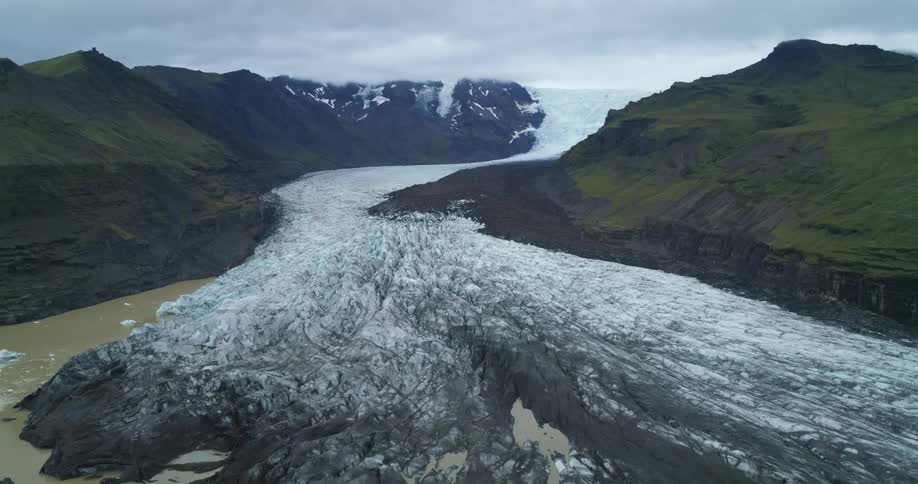A huge glacier is extending down mountains in the arctic
