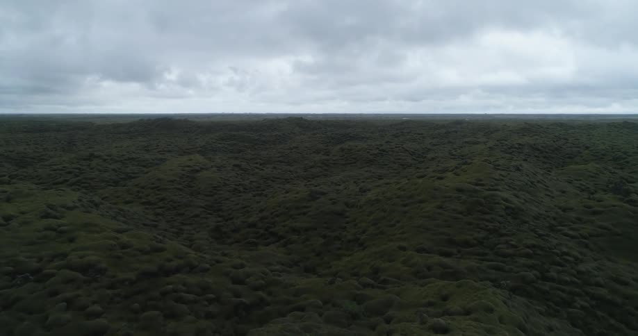 A landscape with hills and dirt with the sky and clouds in the background