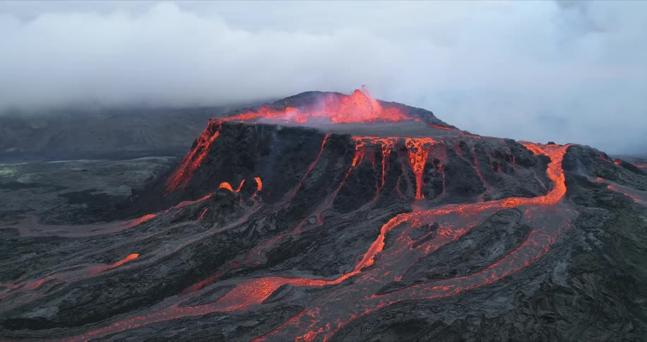 An aerial view of a volcano with lava flowing