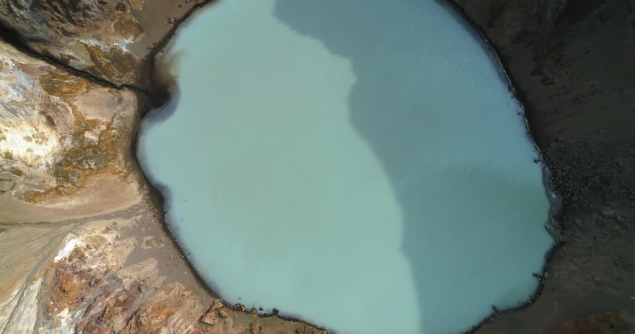 An aerial view of a lake in a crater on a mountain