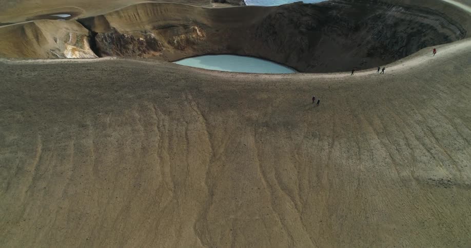 Tourists visit blue hot springs in craters at the bottom of a canyon
