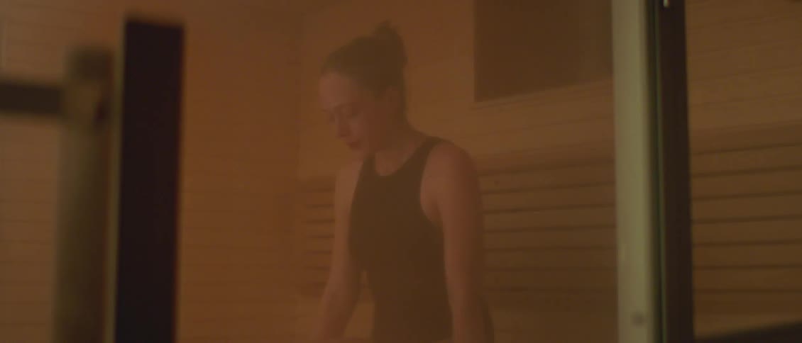 A woman is sitting in the sauna