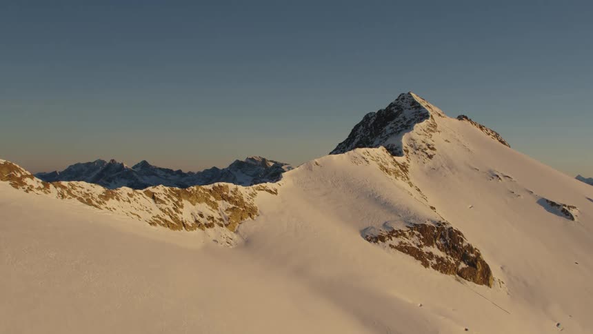 An aerial view of a mountain range covered in snow