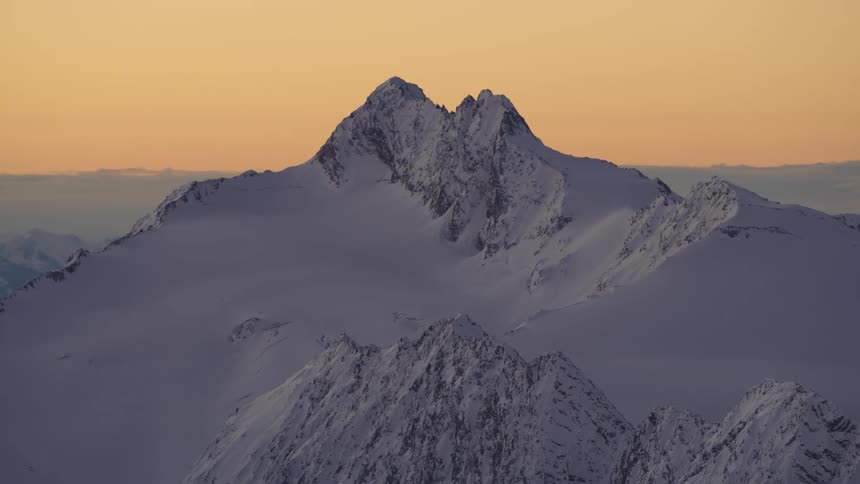 An aerial view of a snow covered mountain range