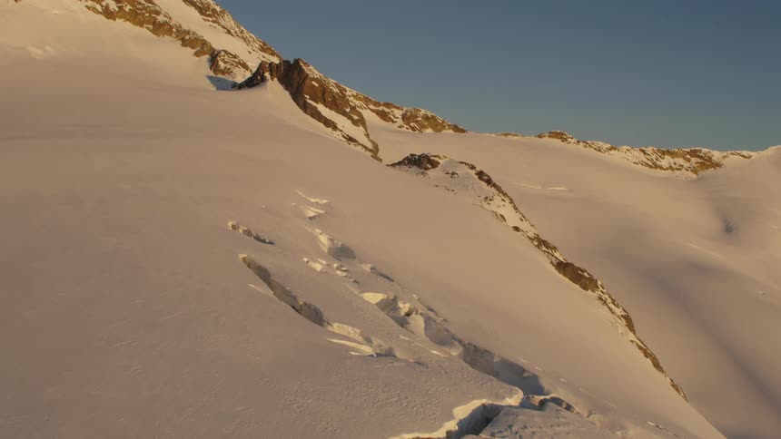 A snow covered glacier with undisturbed snow and crevasses