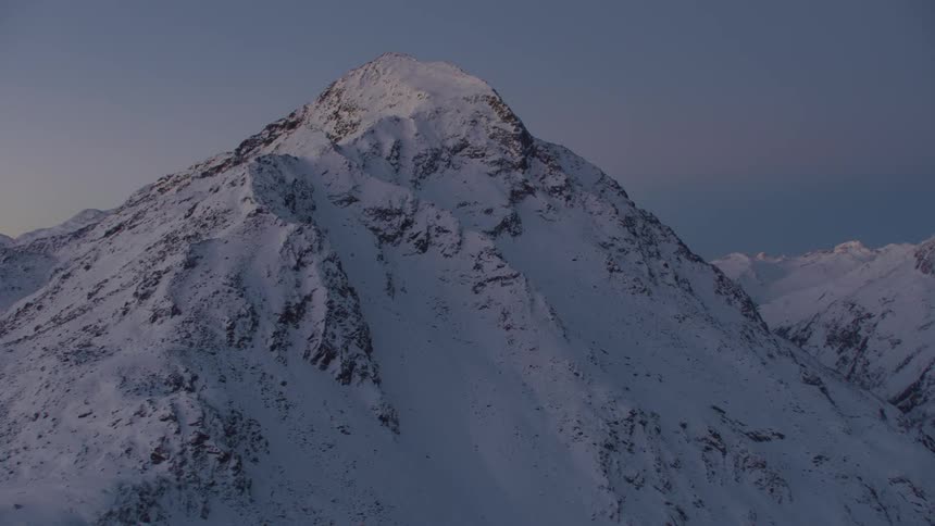 Sun rising on the peaks of a snow covered mountain range in the wilderness