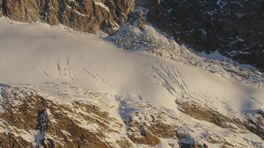 The sunlight shines on thick snow in a mountain range