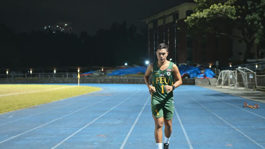 A man is jogging on a track in a field