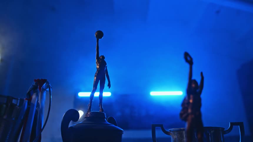 Trophies are lined up under the blue lights