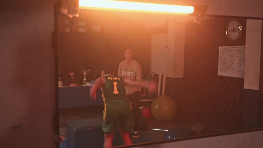 Mirror reflects athlete exercising with encouragement in room with trophies