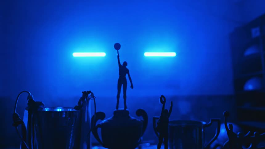 Trophies on a shelf in a room with exercise equipment