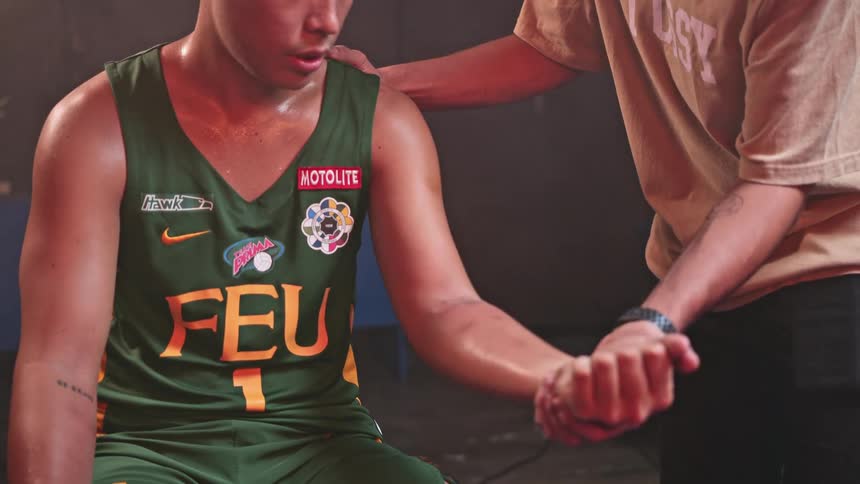 A trainer checks on an athletes wrist in a back room