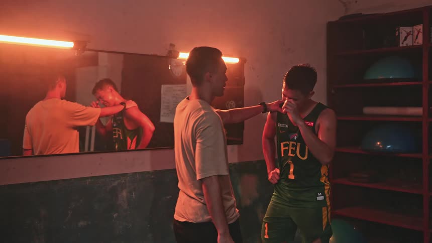 A coach is instructing an athlete in a room in a sports facility with glowing lights