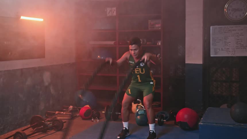 Male athlete exercises with ropes in gym near weights