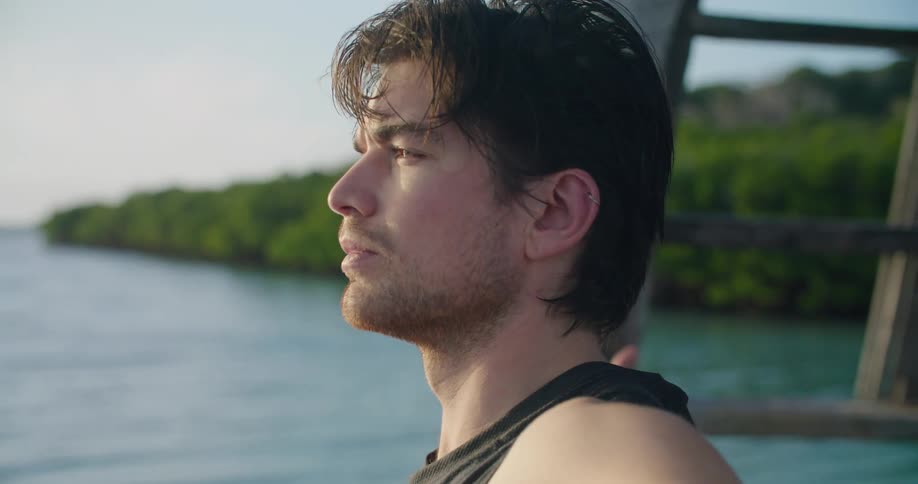A man is doing yoga by the water